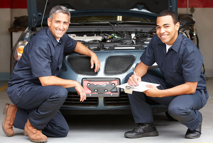 Image of two auto mechanics in front of a car